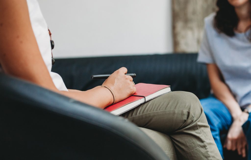 Zwei Personen sitzen zugewandt im psychologischen Beratungsgespräch. 